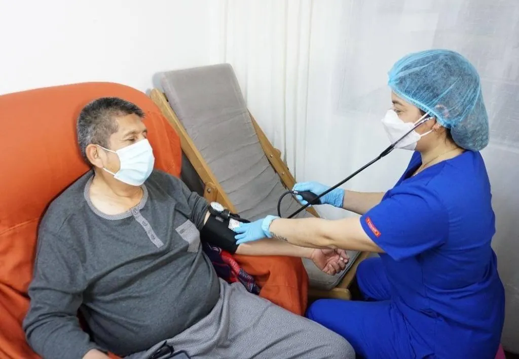 Profesional de la salud tomando presión arterial a paciente